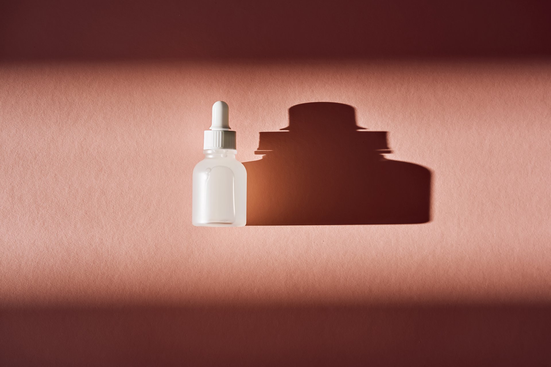 Skincare product packaging with a deep shadow creating an abstract aesthetic
