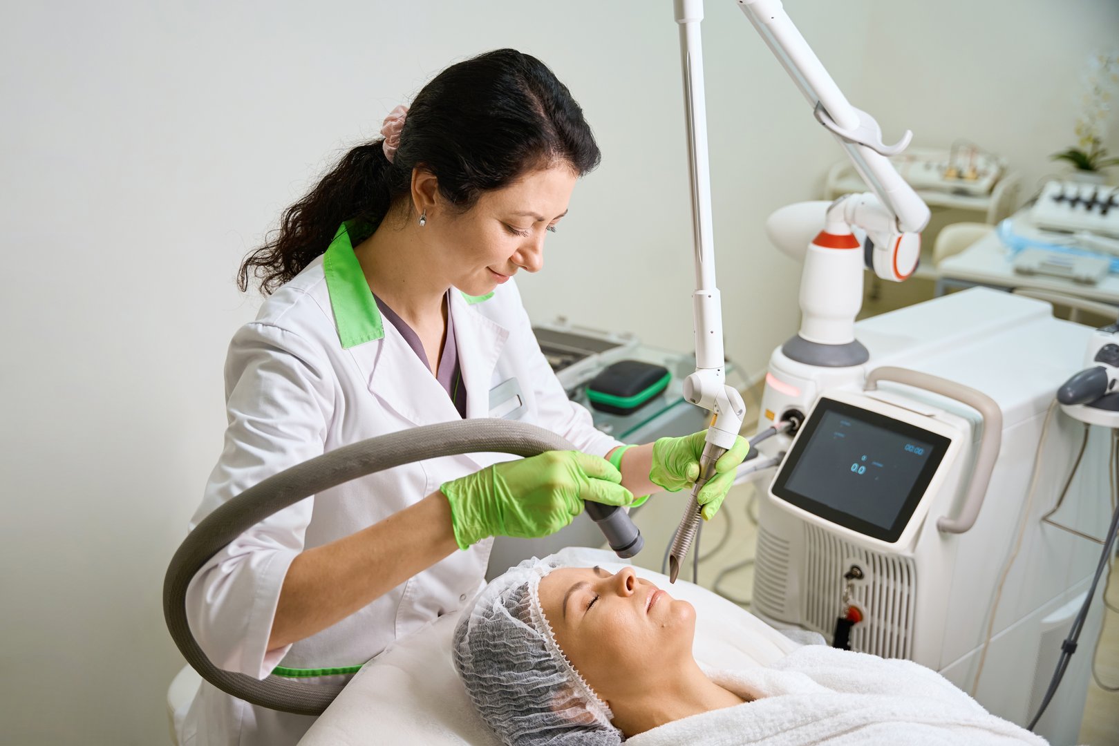Middle-aged lady undergoing a hardware cosmetology procedure, the doctor is wearing protective gloves