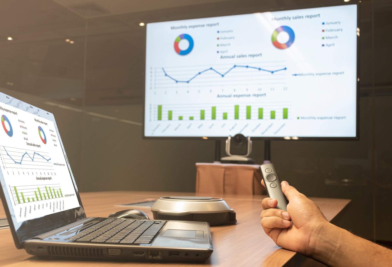 two presentation screens and a person holding a remote
