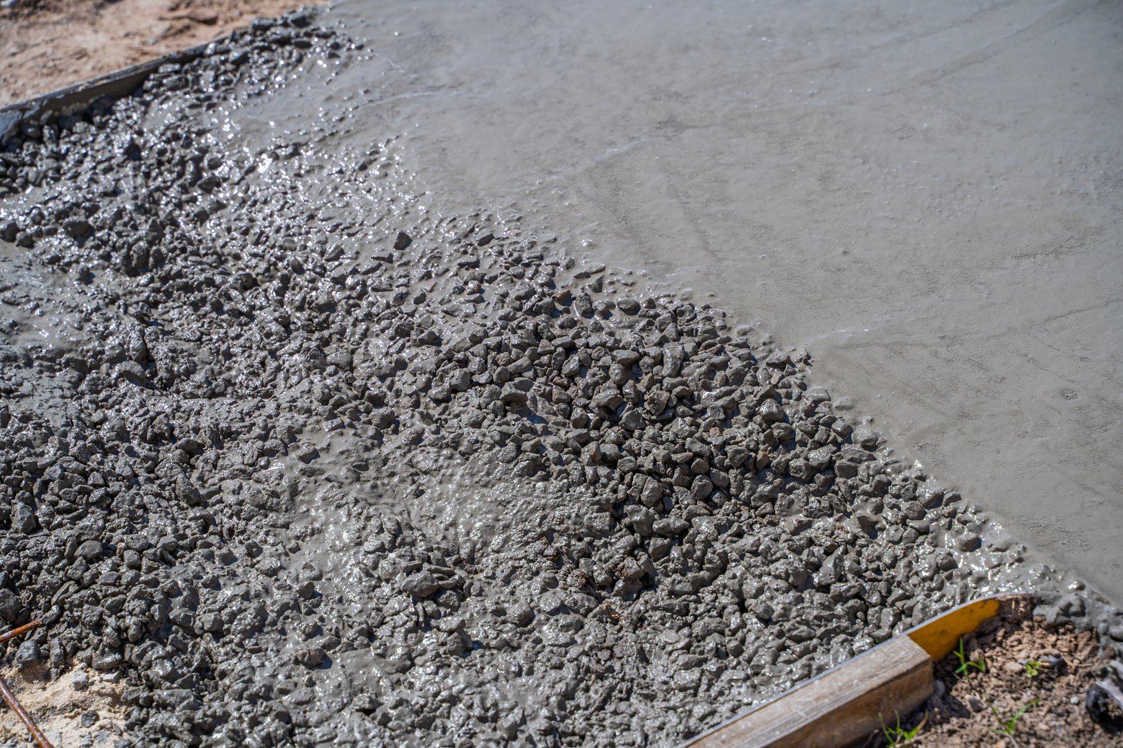 The process of pouring concrete on a path on a sunny day, close-up.