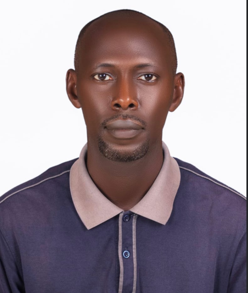 Portrait of a person wearing a dark collared shirt, looking directly at the camera against a plain white background.