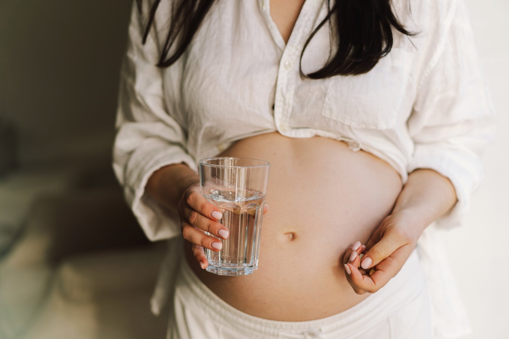 Pregnant drink water. Beautiful pregnancy drinking water. Happy pregnant woman holding glass of water. Pregnancy and Health Concept, maternity.