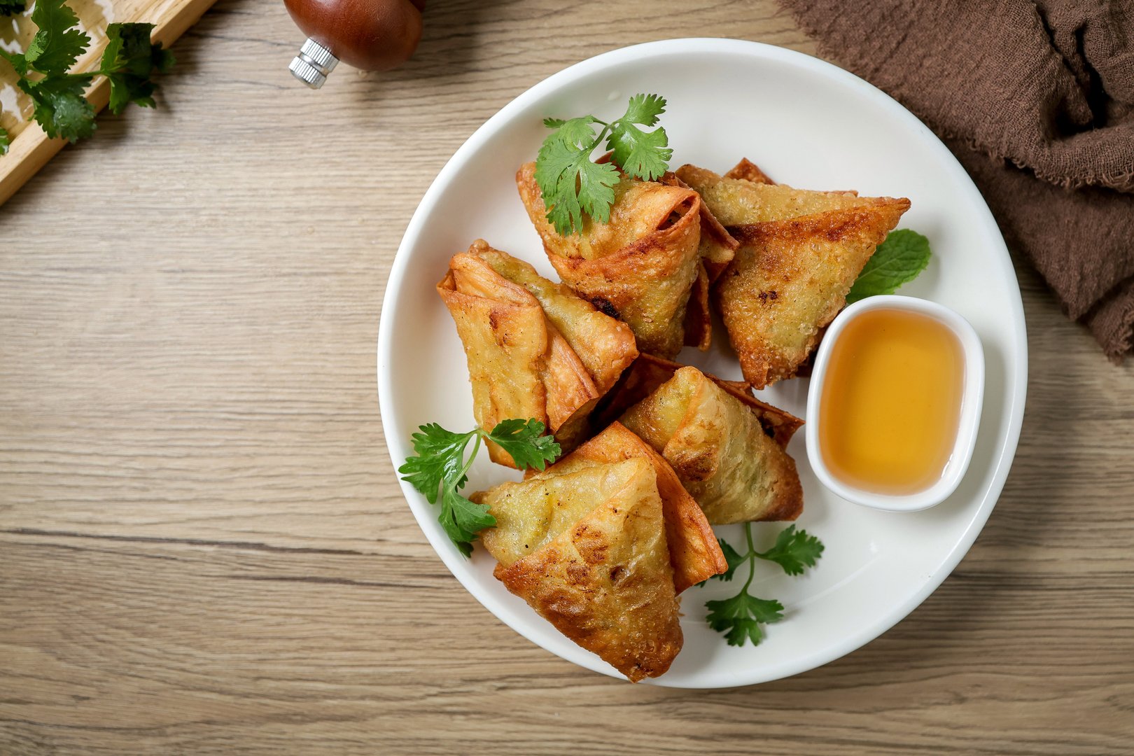 Samosas in a white plate on wooden background, indian fried samosa, indian snack