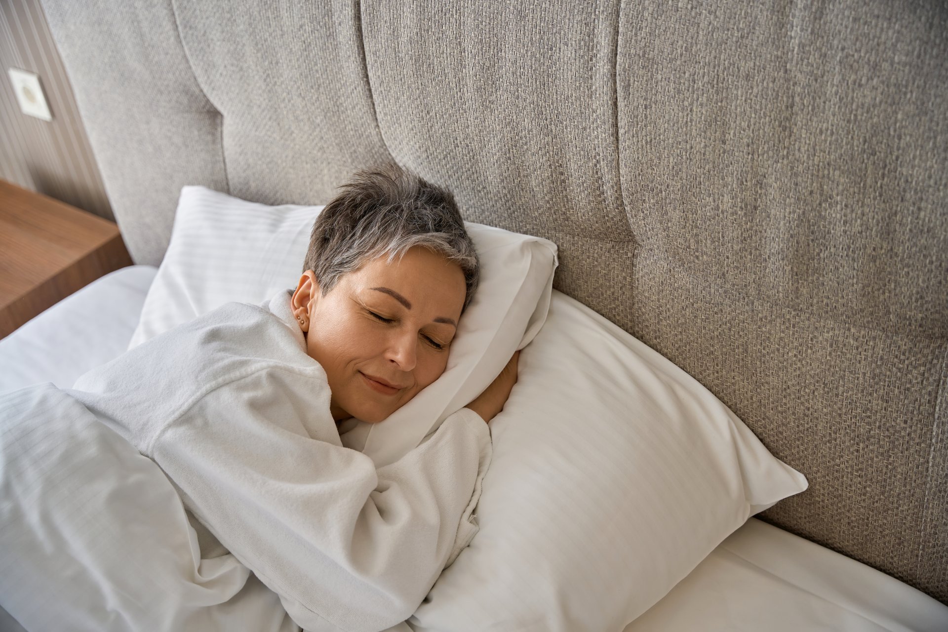 Adult lady in white bathrobe resting