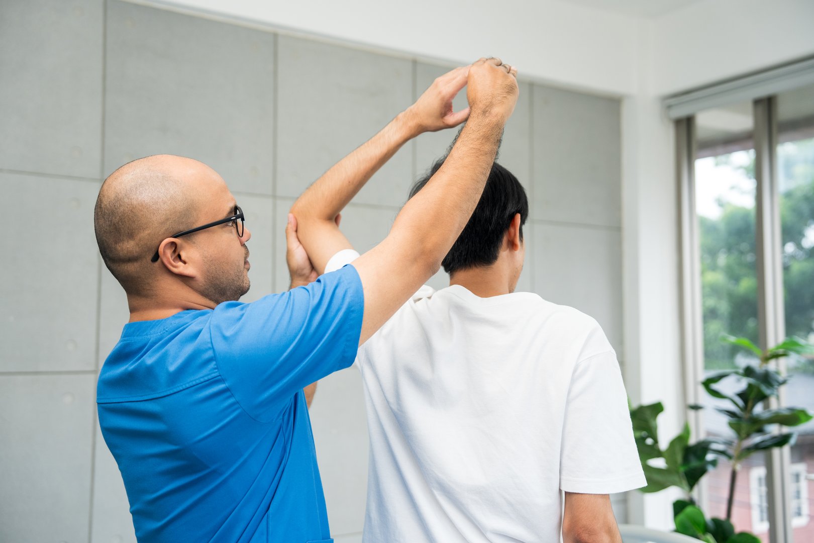 Physical therapy. Male Nurse aids young man in recovering from spine injury and providing orthopedic massage Orthopedic healthcare and chiropractor with person for physical therapy rehabilitation