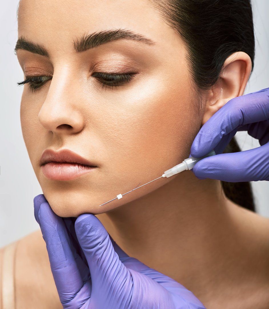 Mesothreads facial. Face contour lifting procedure, a needle with mesothreads near a female face, close-up