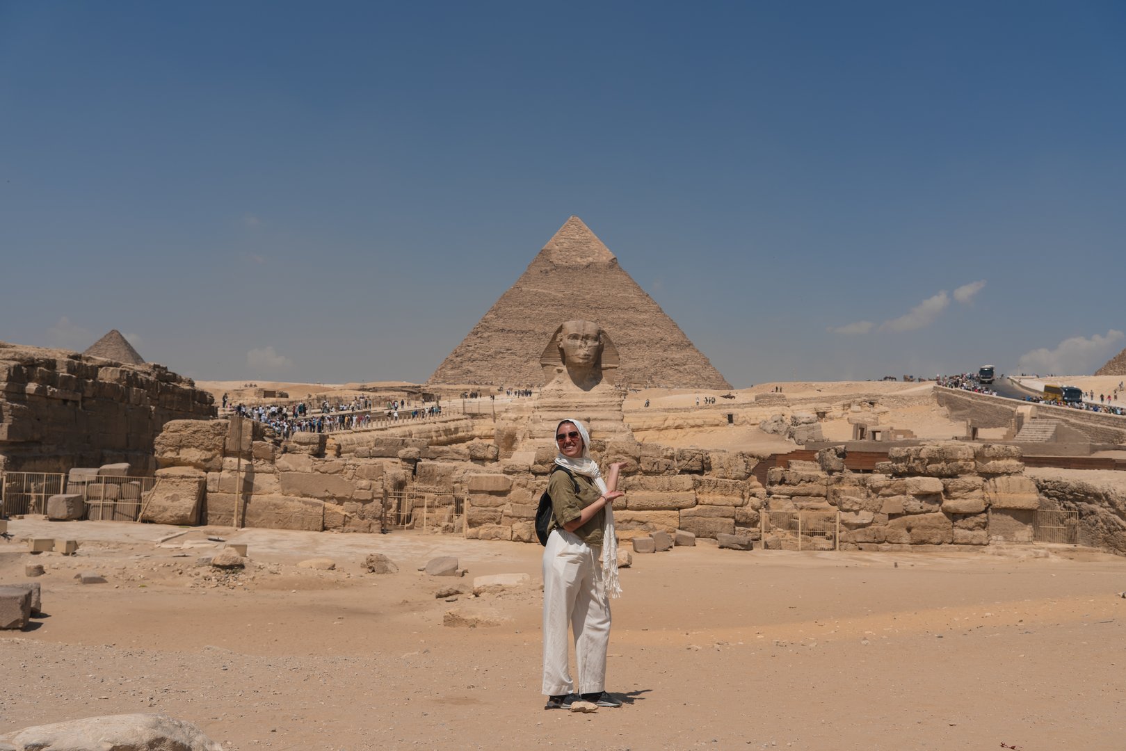 Tourist posing in front of the great pyramid of giza and the sphinx in egypt