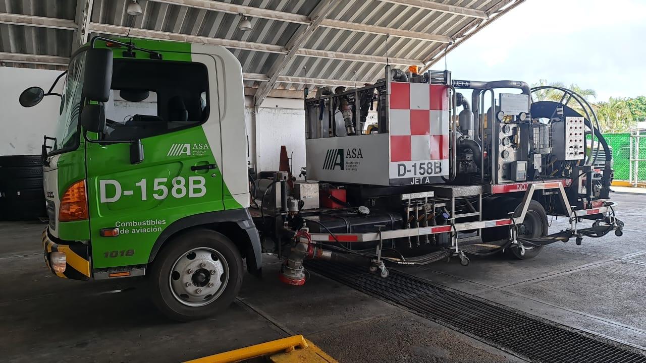 Green and white fuel truck with ASA D-158B parked in a garage, used for aviation fuel distribution.