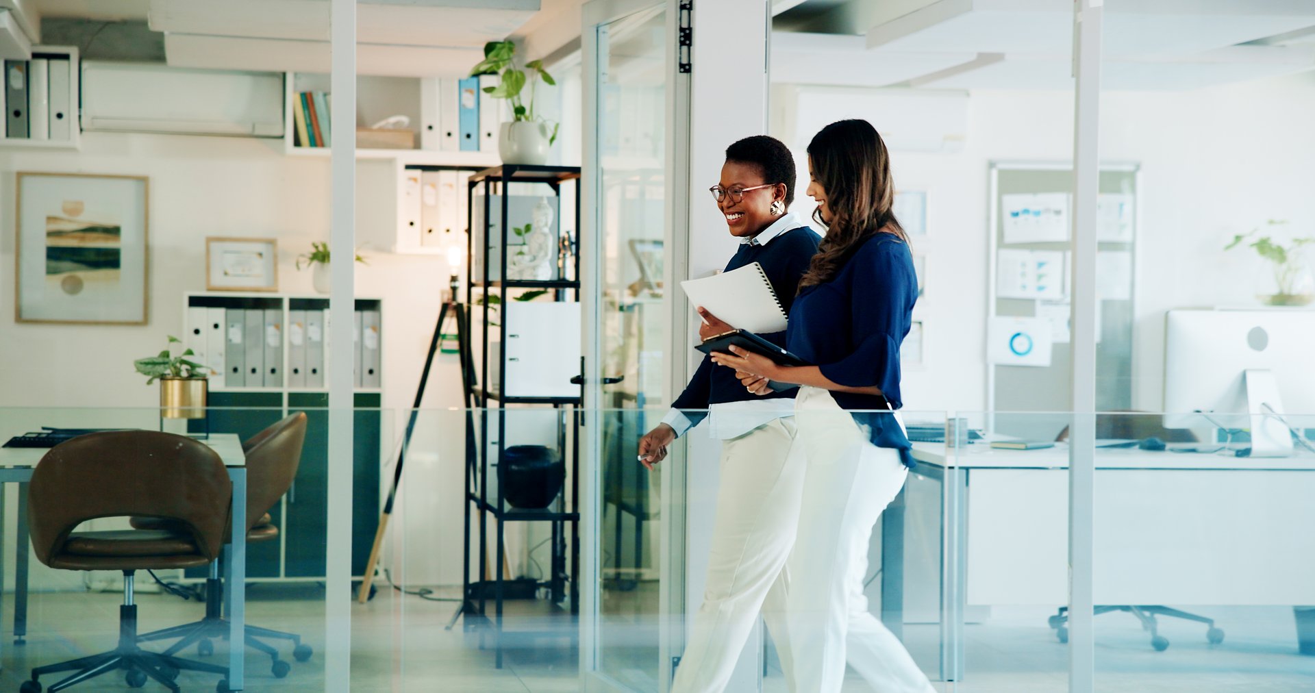 Business women, job and office with walking, communication and smile from teamwork and discussion. Lawyer, conversation and attorney workers together with diversity of professional team at law firm