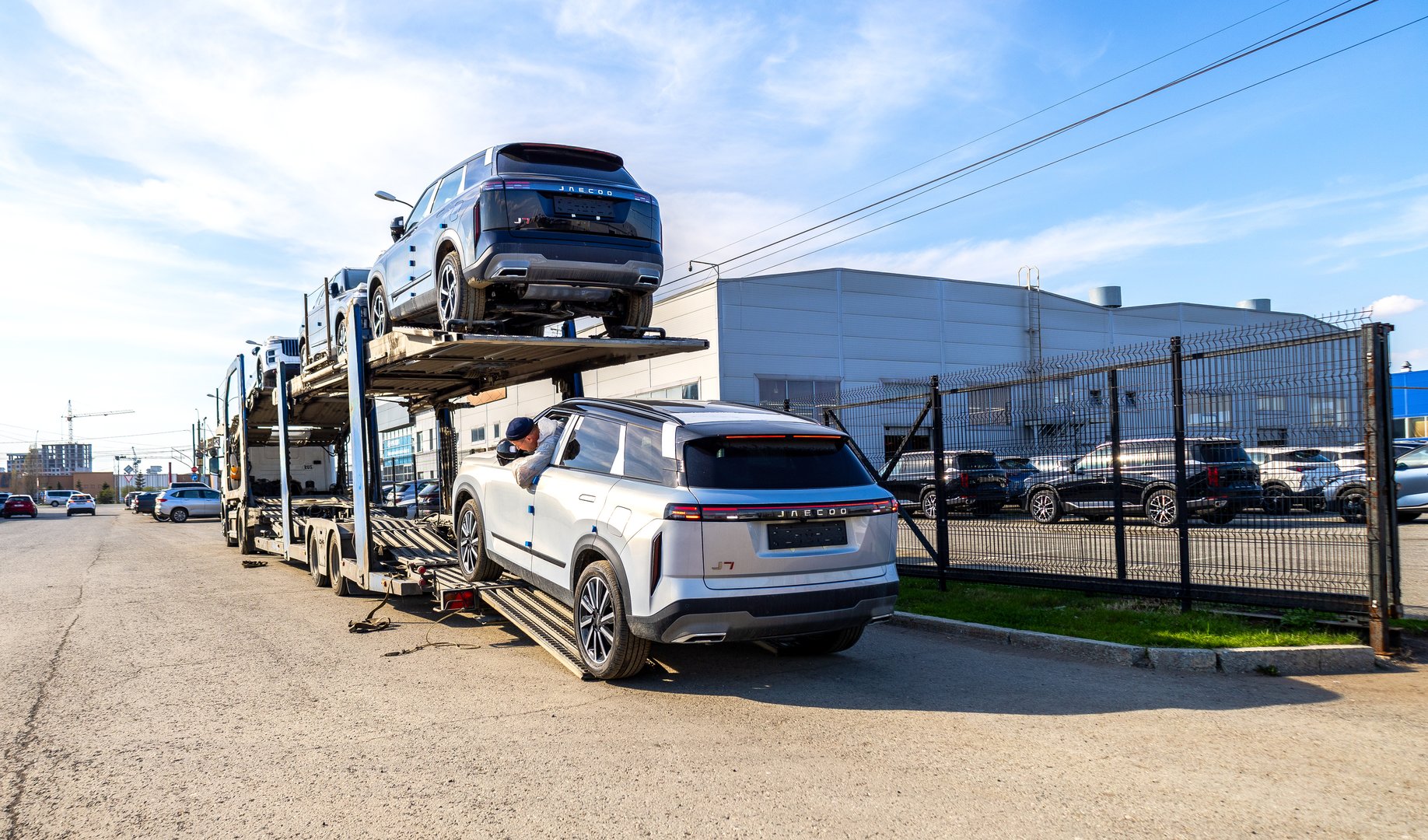 Samara, Russia - April 19, 2025: Car carrier brought new cars to official dealer. Car carrier transporter truck with Jaecoo vehicles