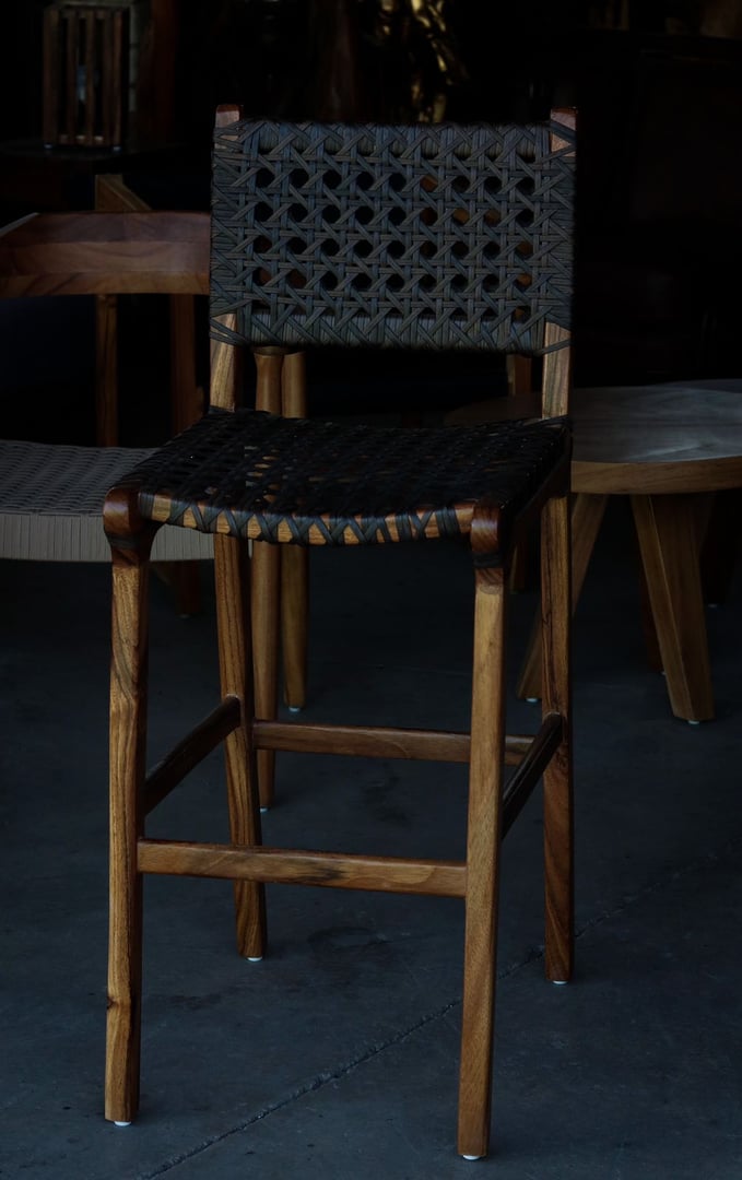 Banco alto con estructura de madera sólida y asiento-respaldo tejido en ratán con patrón cruzado