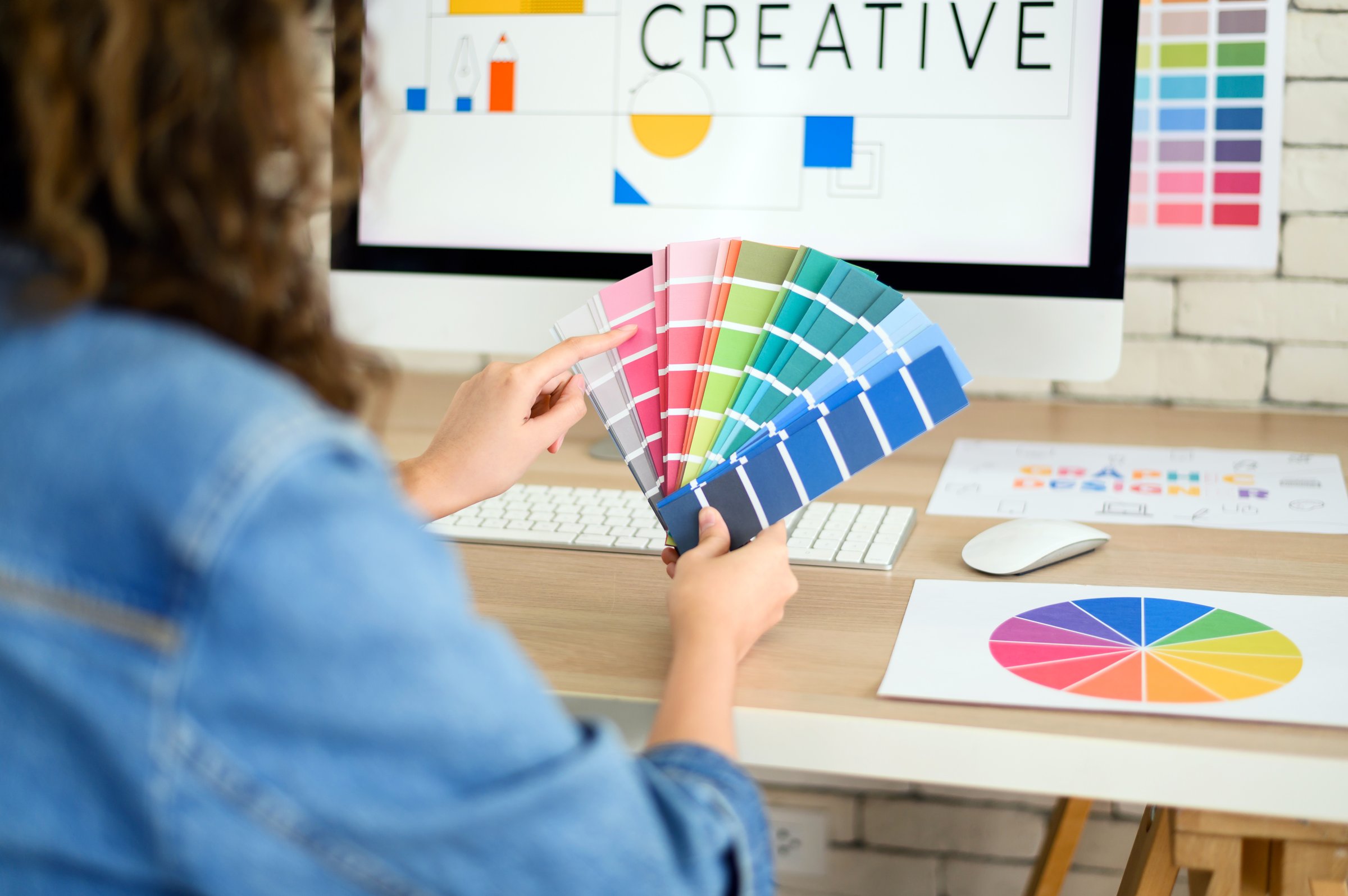 Tânără femeie asiatică designer grafic lucrând cu diagrame de culori și grafică pe computer la birou