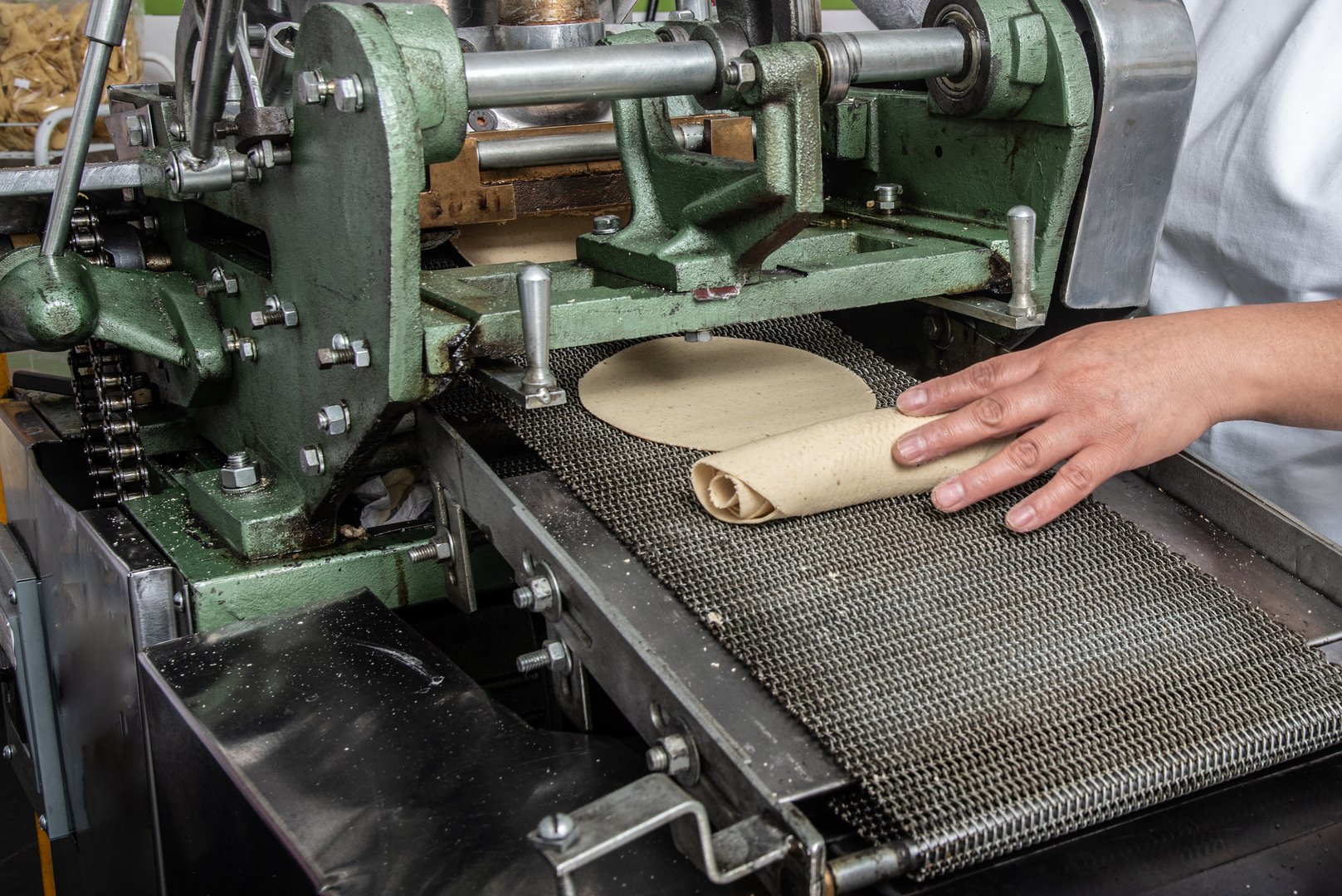 machine to make tortillas Mexican tortilleria with metal band and a kilo of tortillas wrapped in white paper