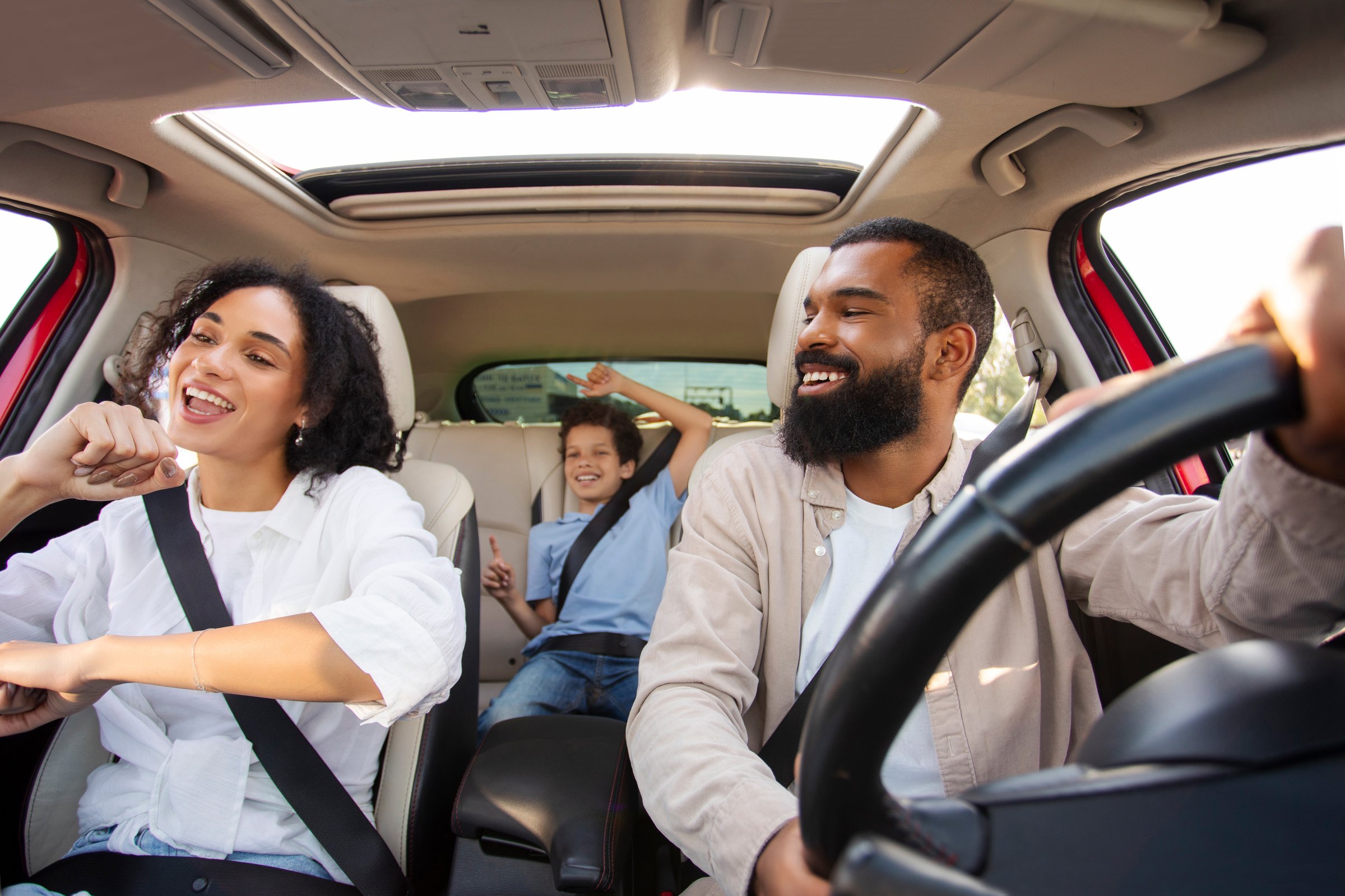 Funky Latin family with son having fun while going somewhere together by car, singing songs and dancing inside auto