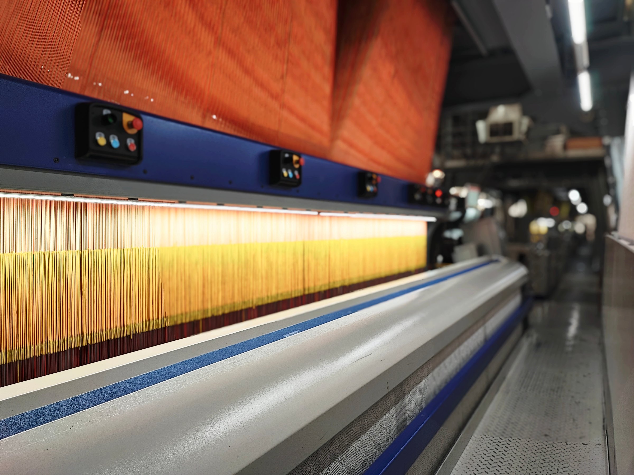 Weaving loom in a textile factory, close-up. Industrial fabric production line Carpet, Curtain, Rug, Tufting machine
