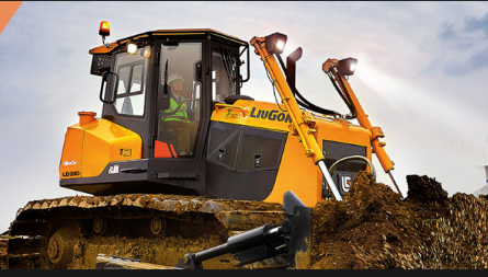 A yellow bulldozer with a cabin light on, digging earth with a large scoop, under a clear sky.