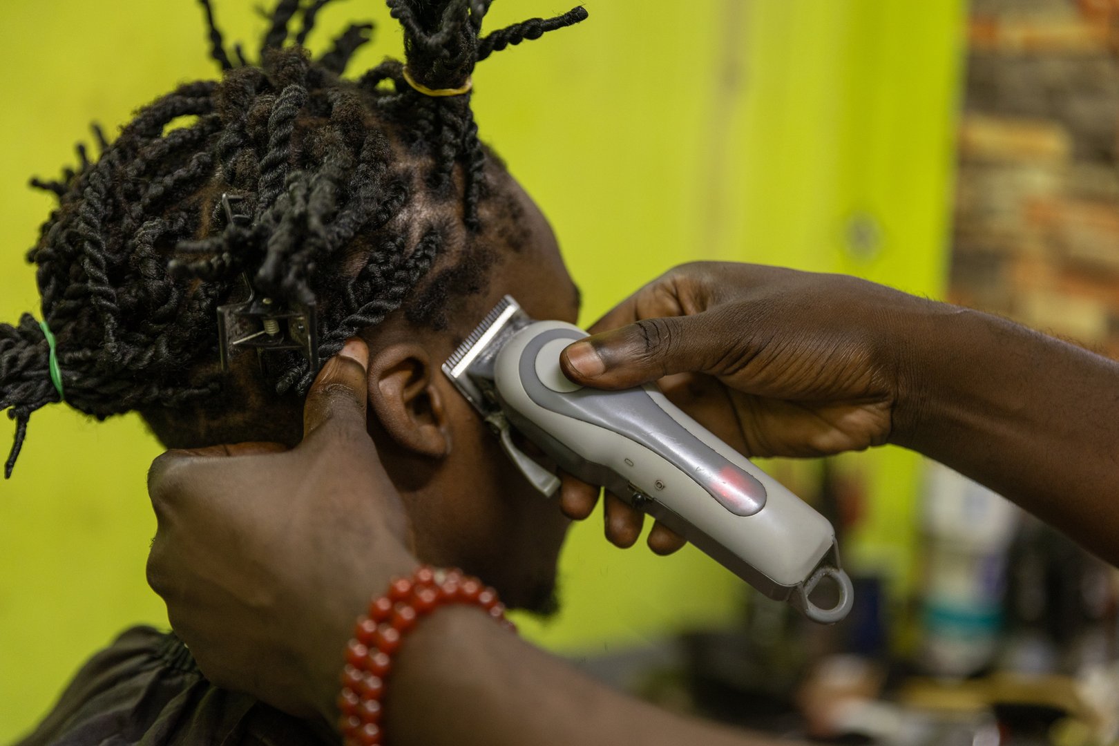 Close up of a customer's head receiving a haircut from his barber in Africa.