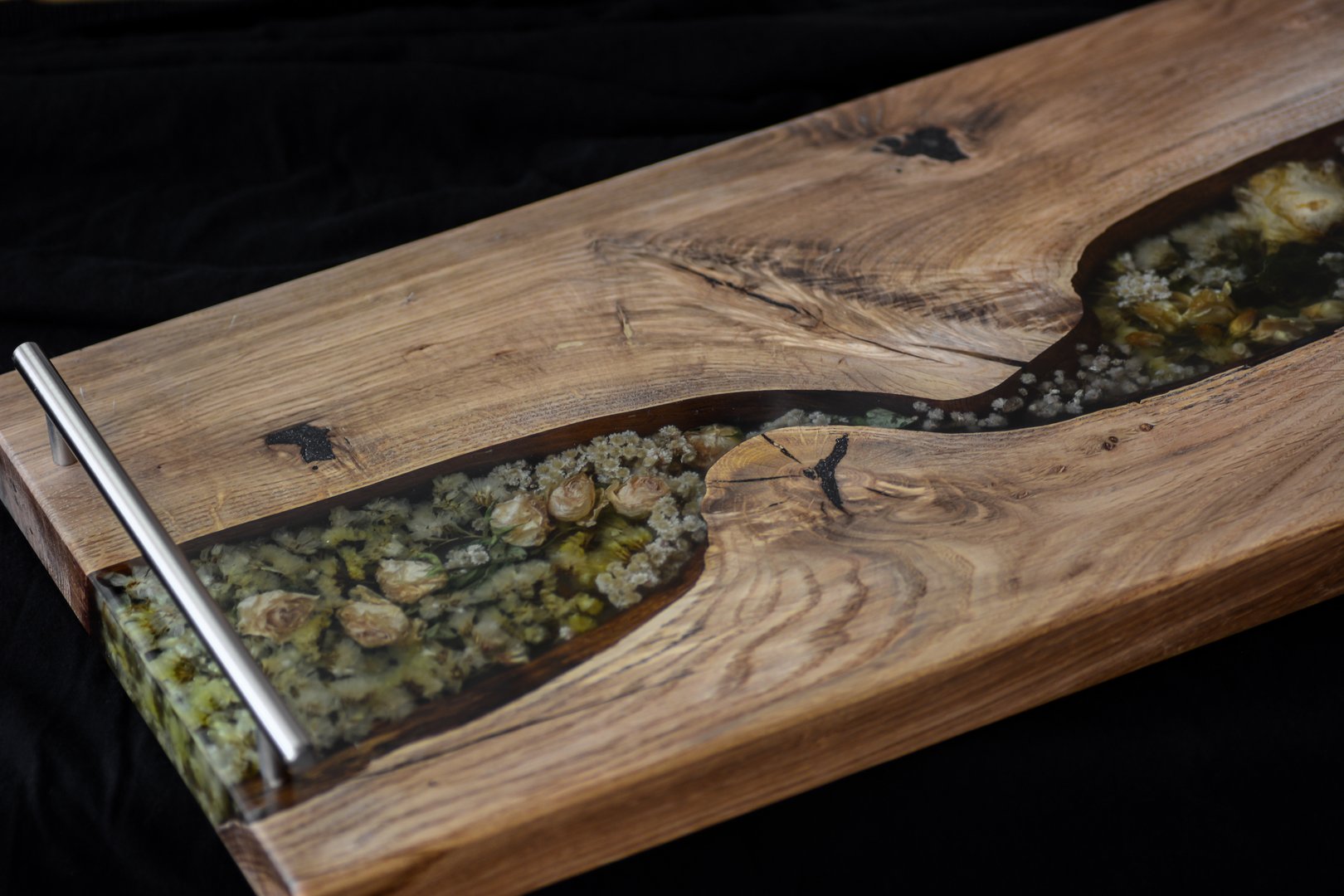 Decorative serving board made of oak and epoxy resin with drowned dried flowers and stainless steel handles