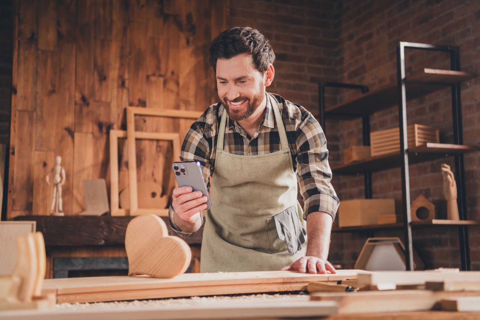 Photo of happy builder guy use cell smart gadget photigraphing heart gift in garage.