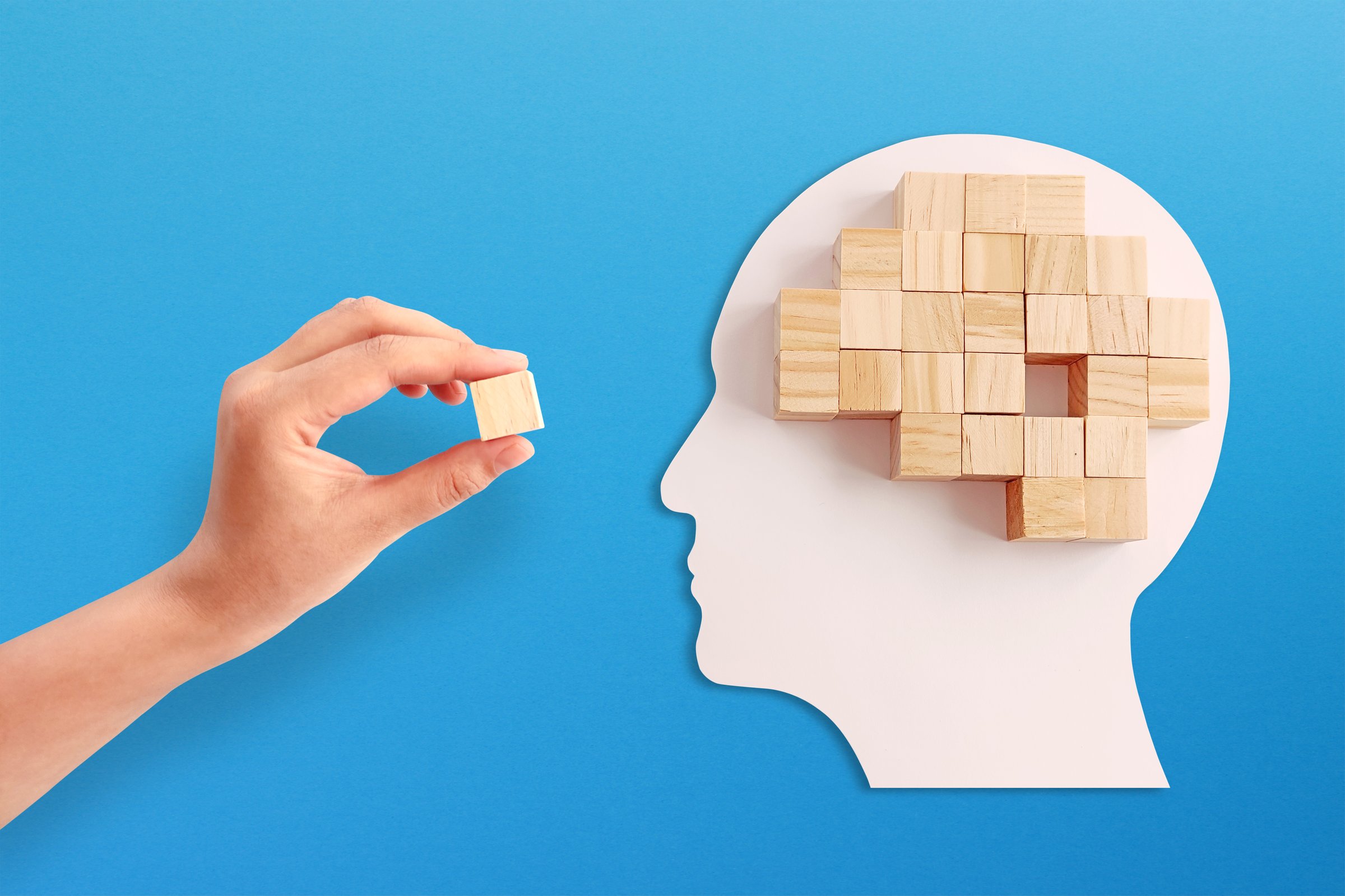 Mental health and problems with memory. Missing piece of the brain puzzle on blue background.