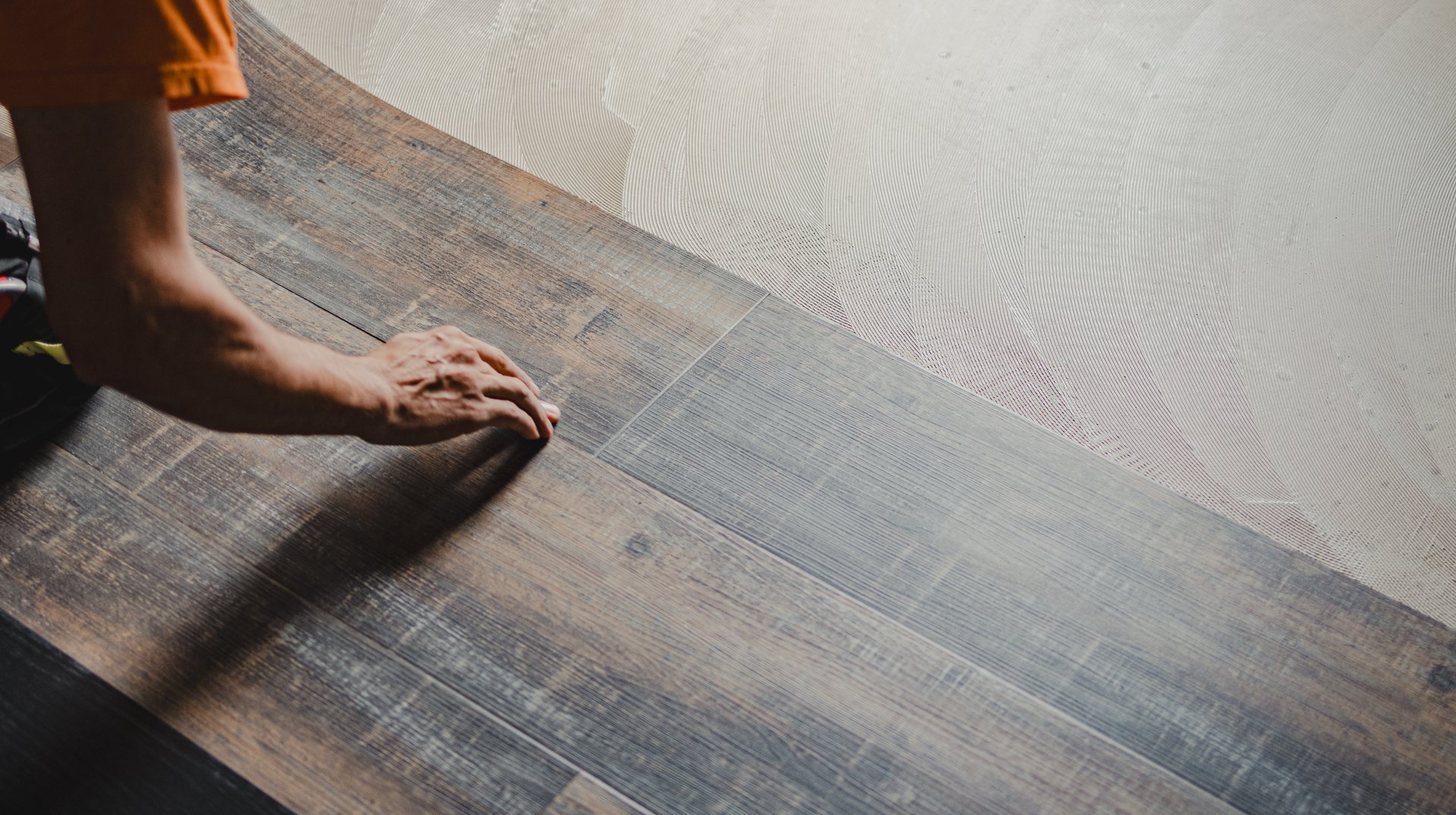 Professional builder laying vinyl tile flooring, using adhesive for perfect installation