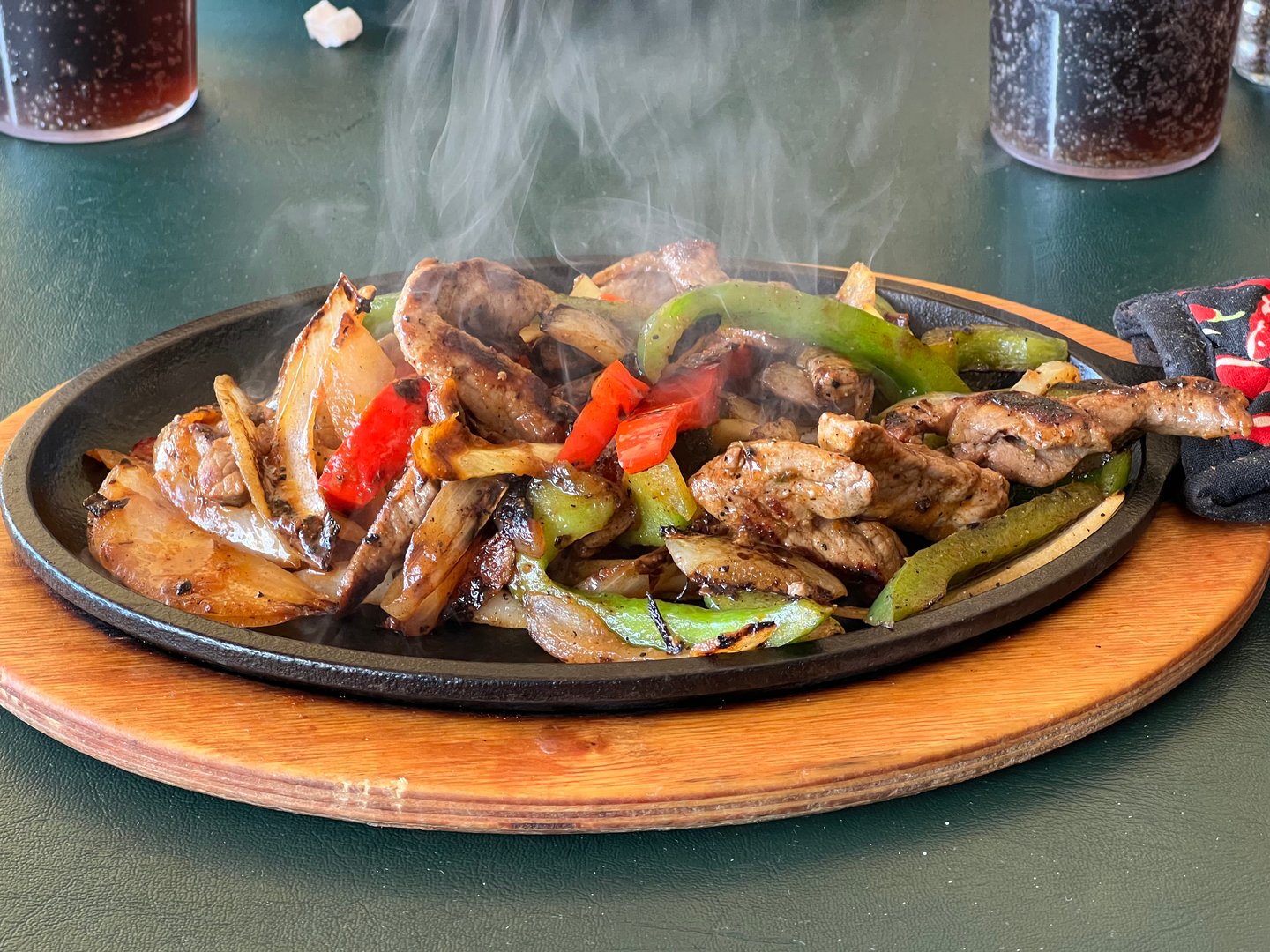 A platter of fresh, hot, sizzling steak fajitas.