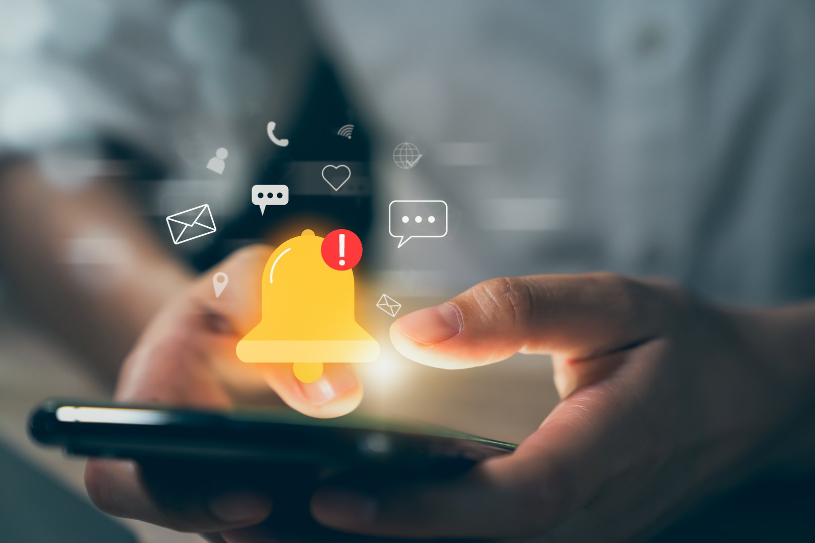 Hand using smartphone with showing the bell icon and notifications of new messages on application.