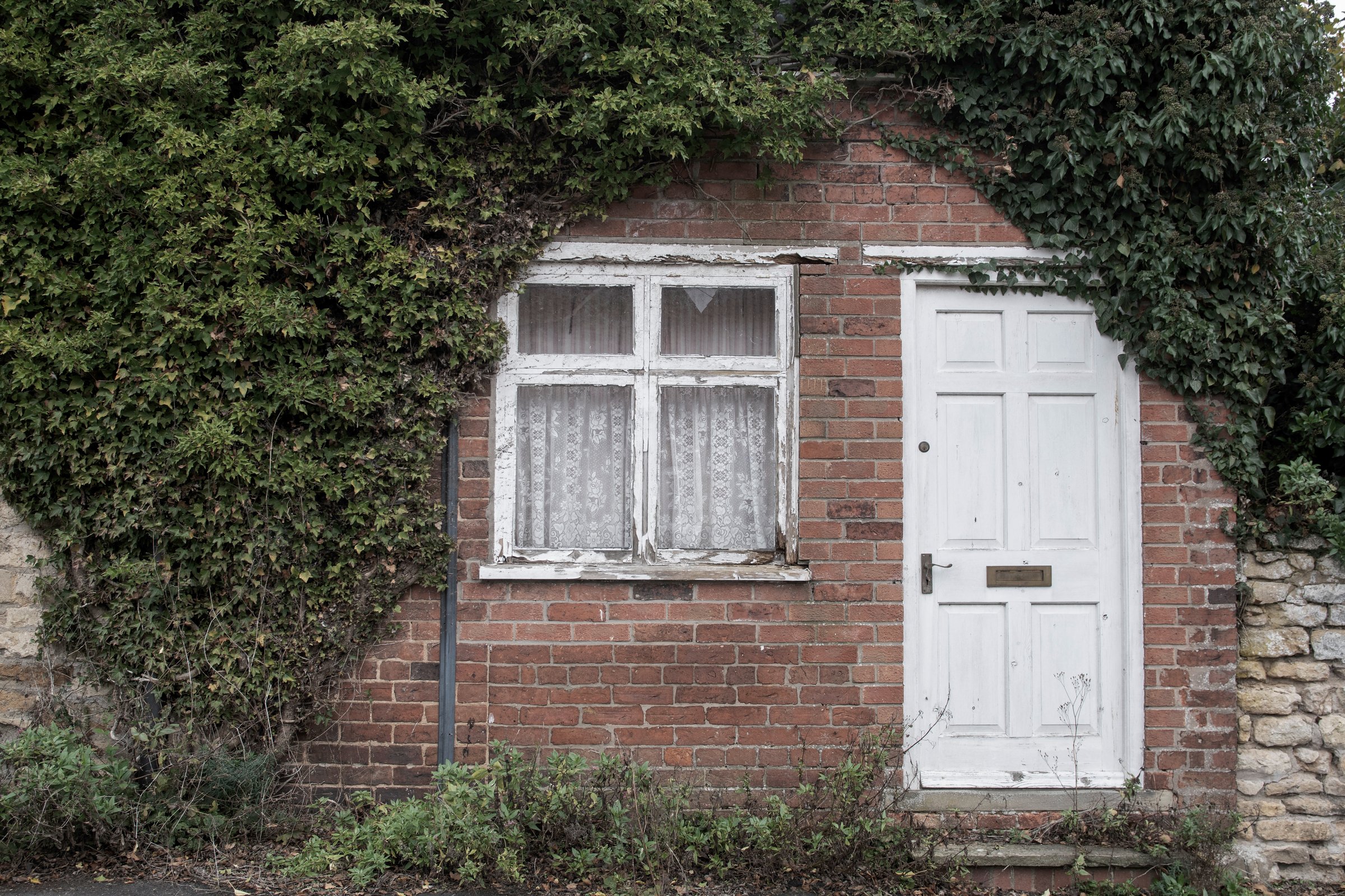 A colour image of a rundown font of house