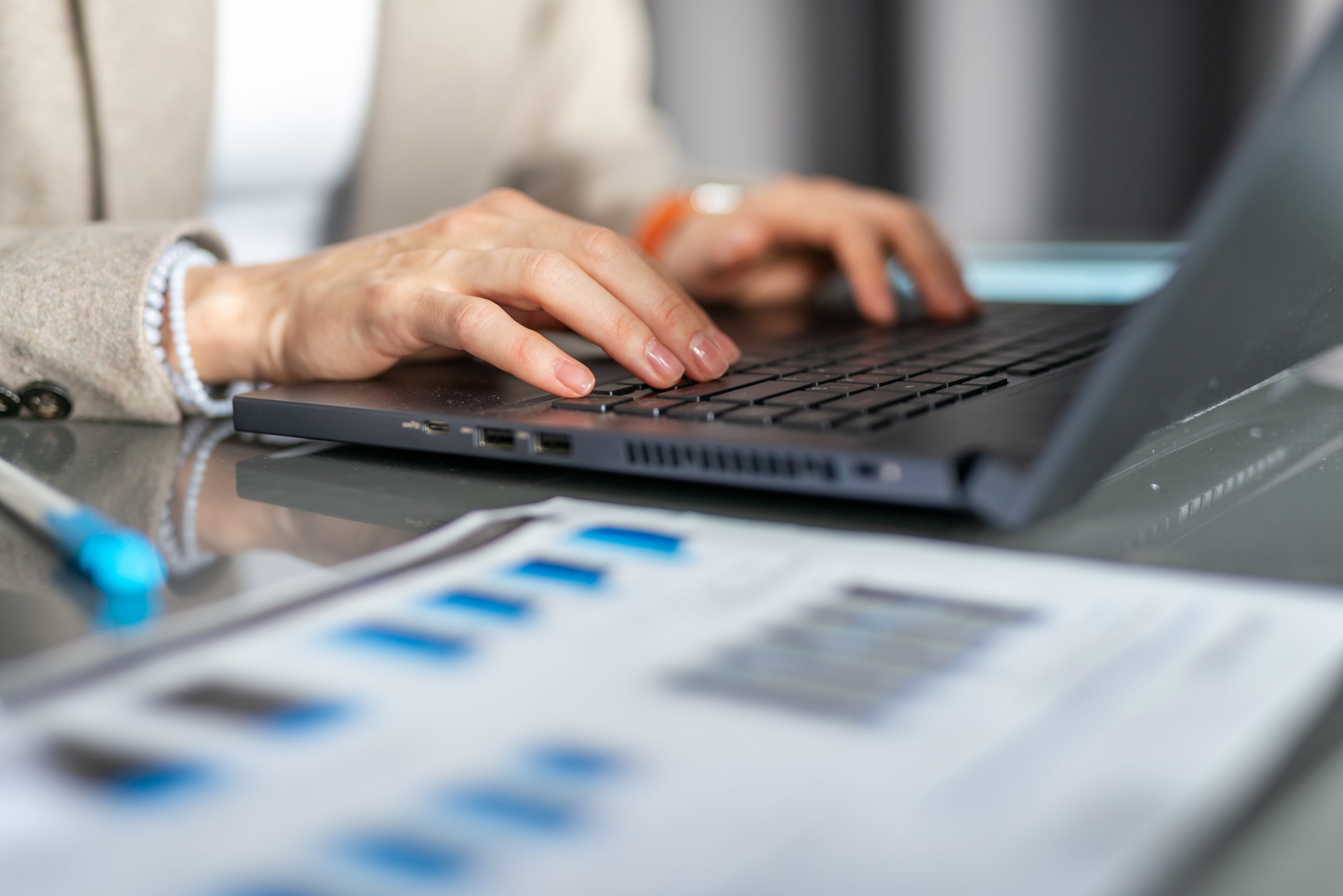Female hands laptop keyboard documents desktop data analysis statistics report finance and investment