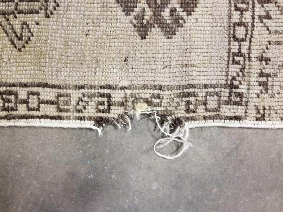 Before: Rug with damage requiring professional repair