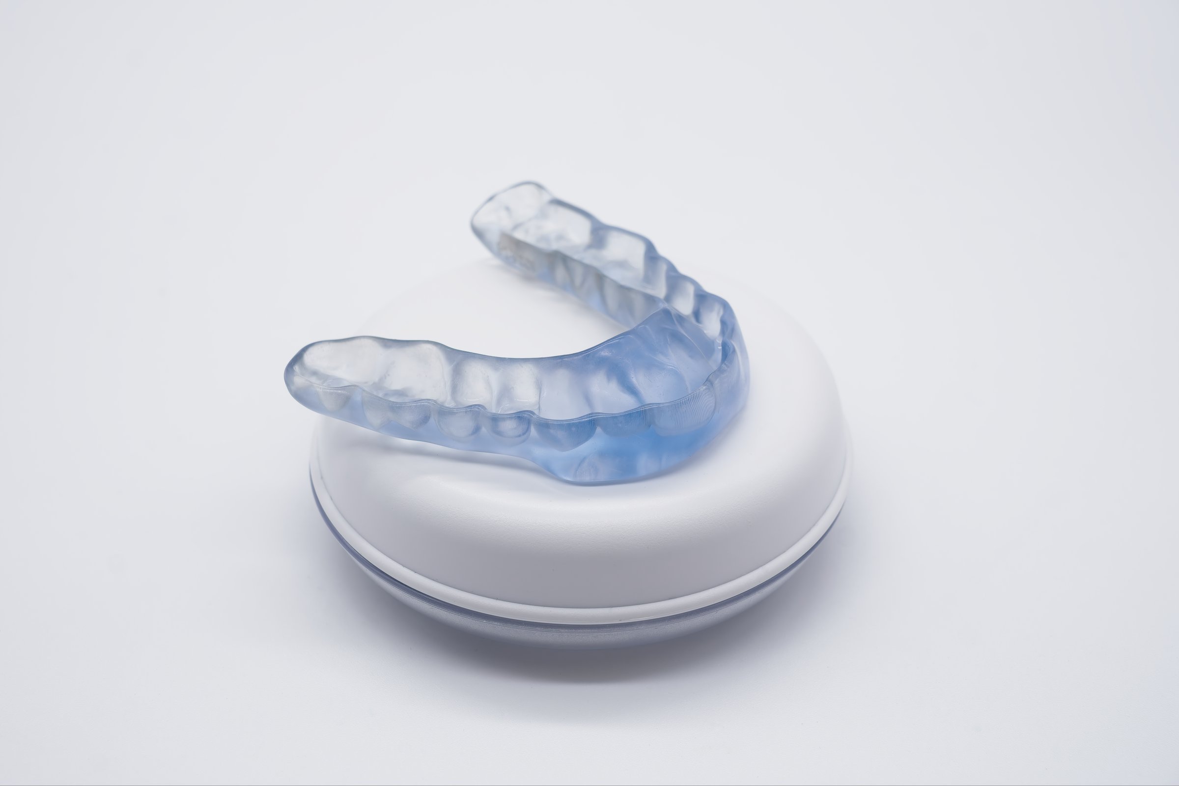 Custom-made dental night guard resting in its case, providing essential protection against teeth grinding and promoting better oral health