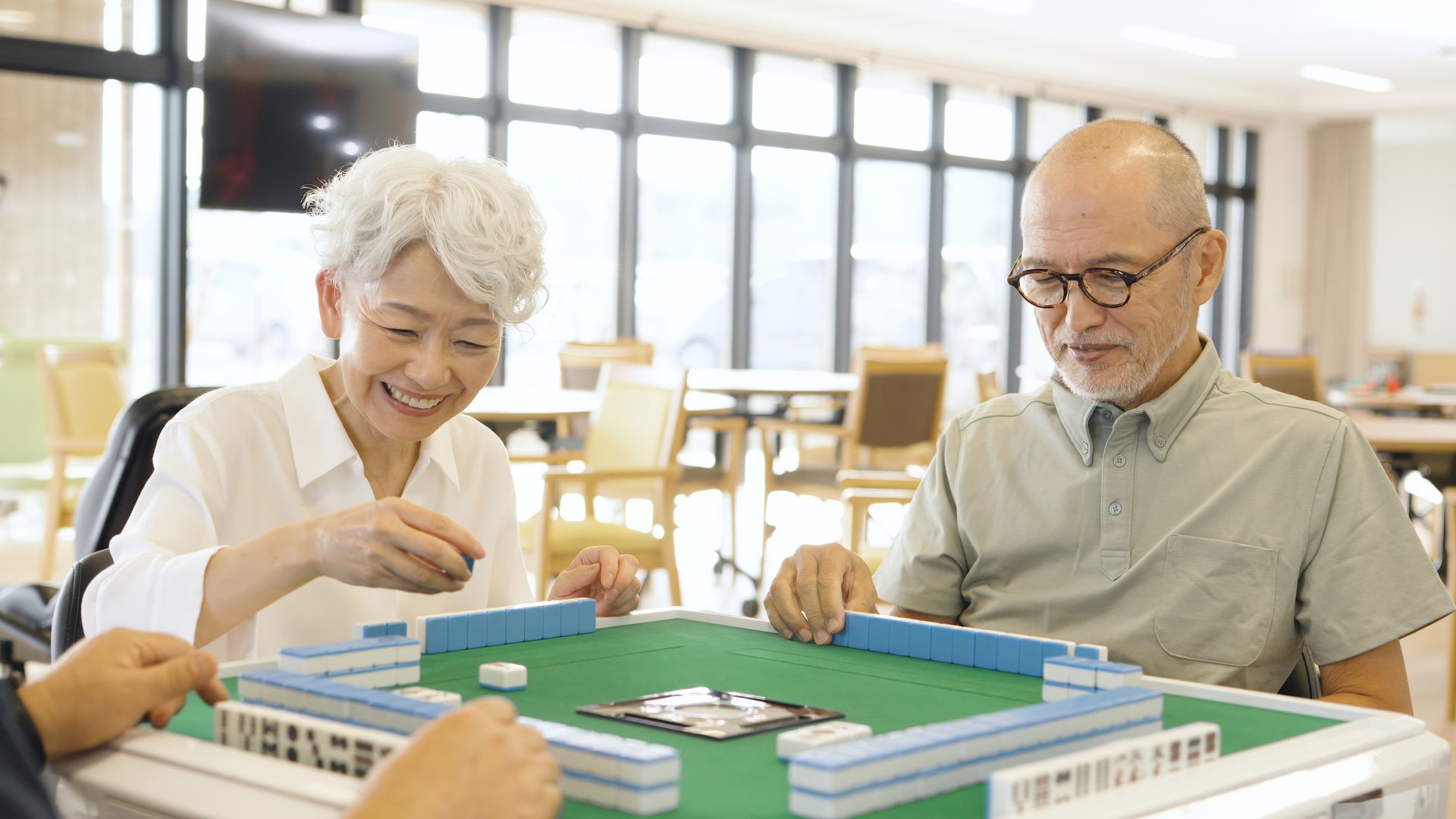 Asian elderly people playing mahjong in a care home