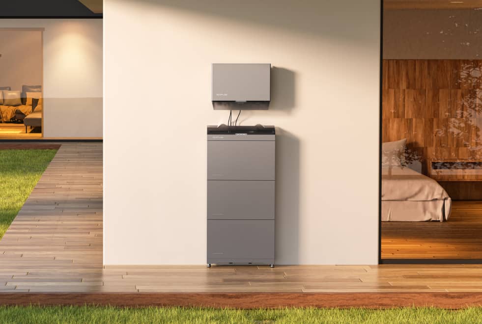 Home battery storage system on an exterior wall, next to a wooden-decked patio and a glass door leading indoors.