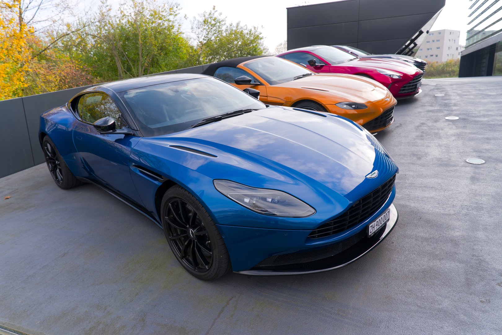 Parked new British Aston Martin sports cars outdoor of luxury car dealership at Swiss City of Opfikon on an autumn day. Photo taken November 8th, 2024, Zurich Opfikon, Switzerland.