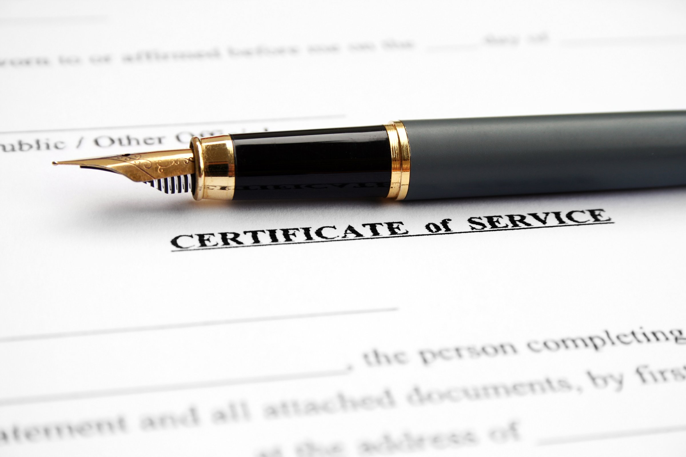 Close-up of a fountain pen on a document titled Certificate of Service.