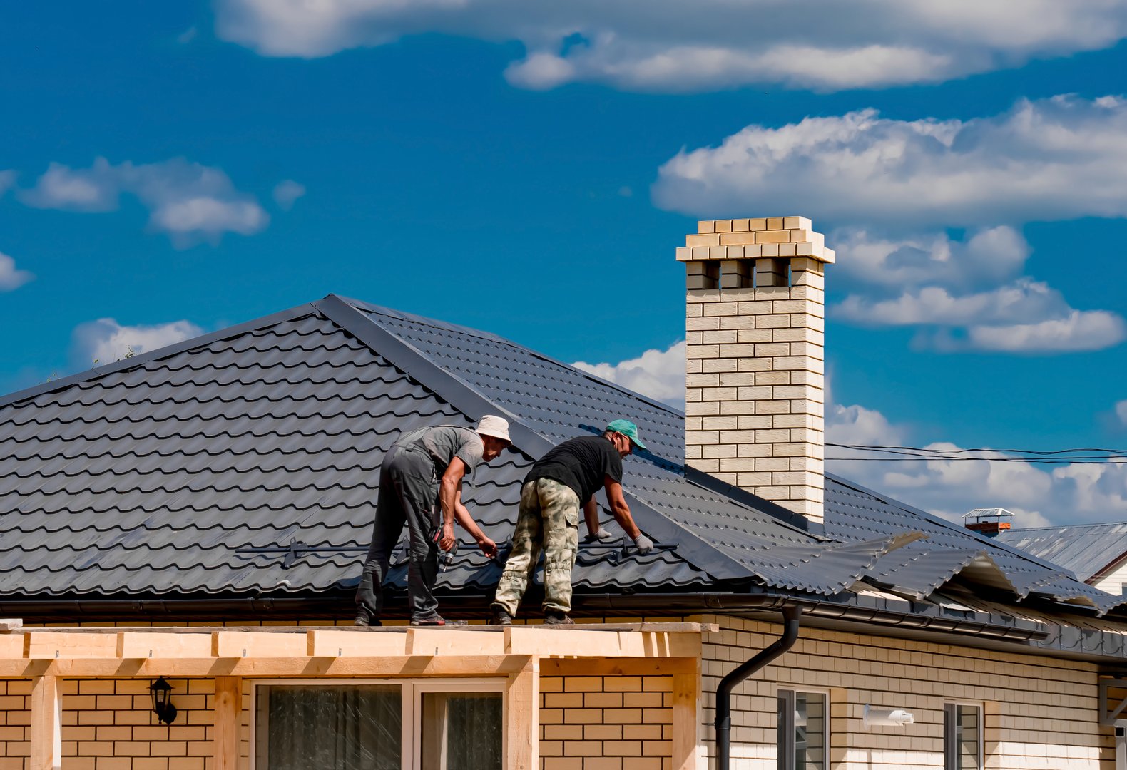 Tatarstan, Russia. July 17, 2022. Installation of metal tiles on the roof of the house. Construction of a house.