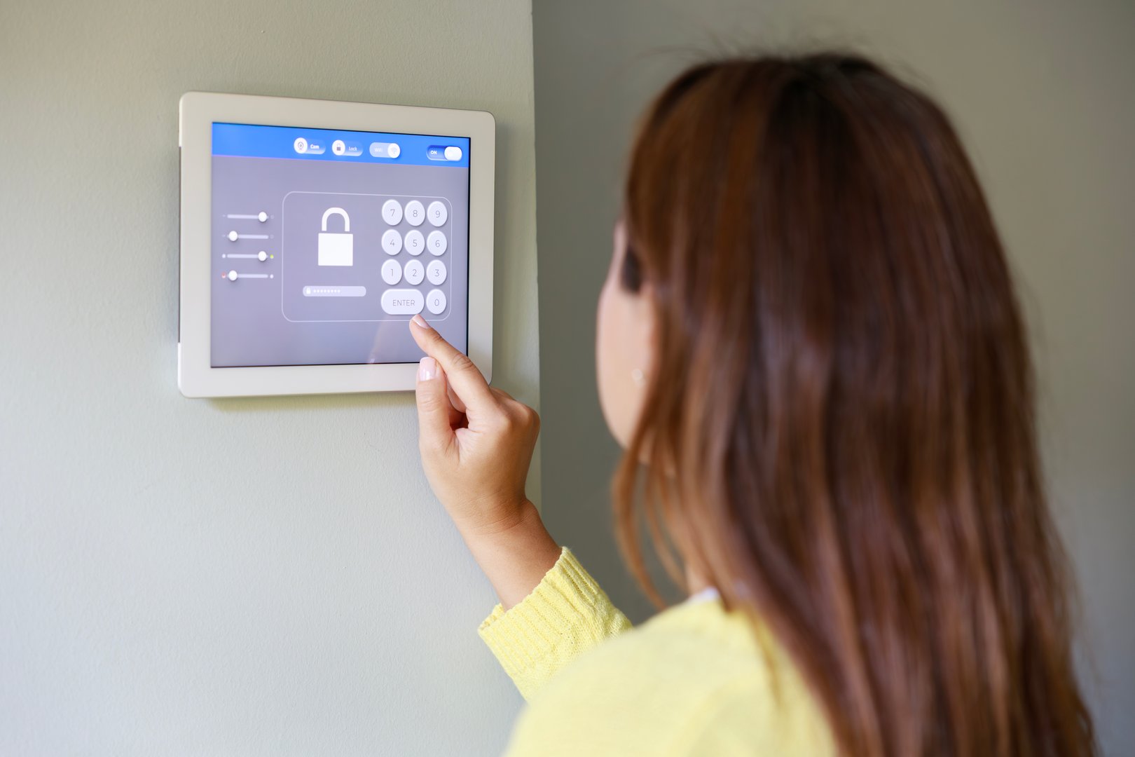 Woman entering pin code to lock the doors using a home automation system