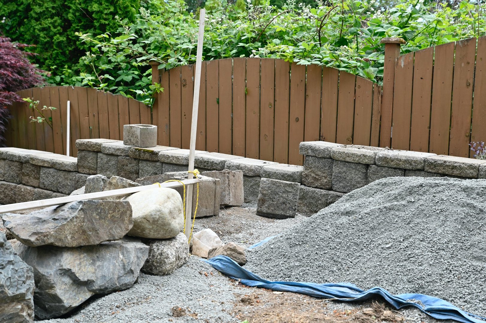 Project is in progress, stone walls for levelling sloped yard, flowerbeds, an outdoor do-it-yourself project.