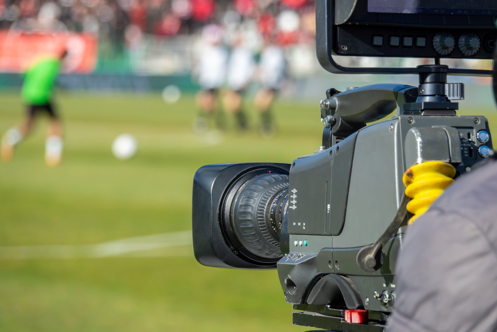 TV camera at the stadium, broadcasting during a football, soccer match