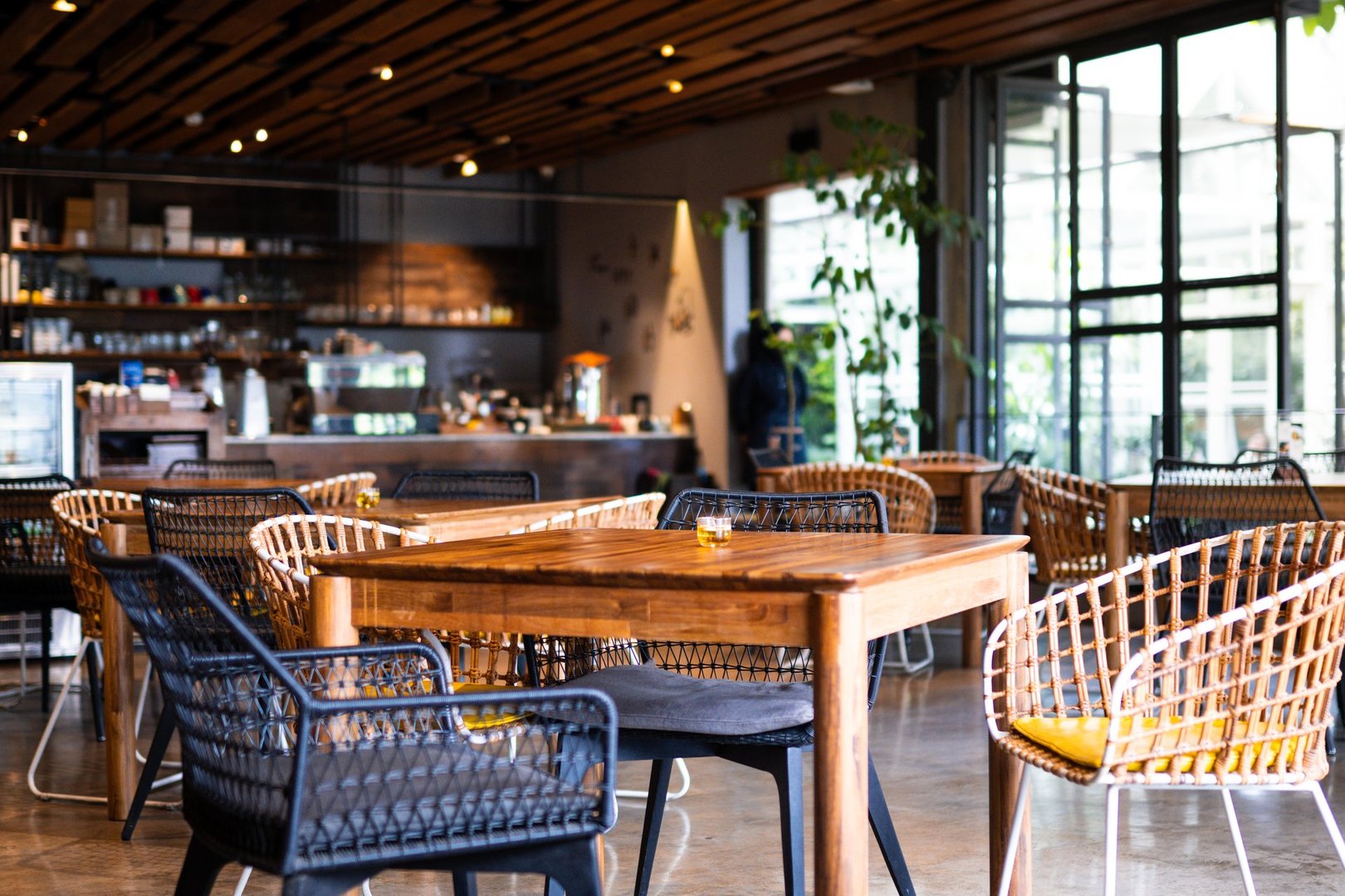 Modern café interior with stylish wooden furniture, sleek decor, and warm ambient lighting, perfect for hosting gatherings or enjoying peaceful moments with a cup of coffee