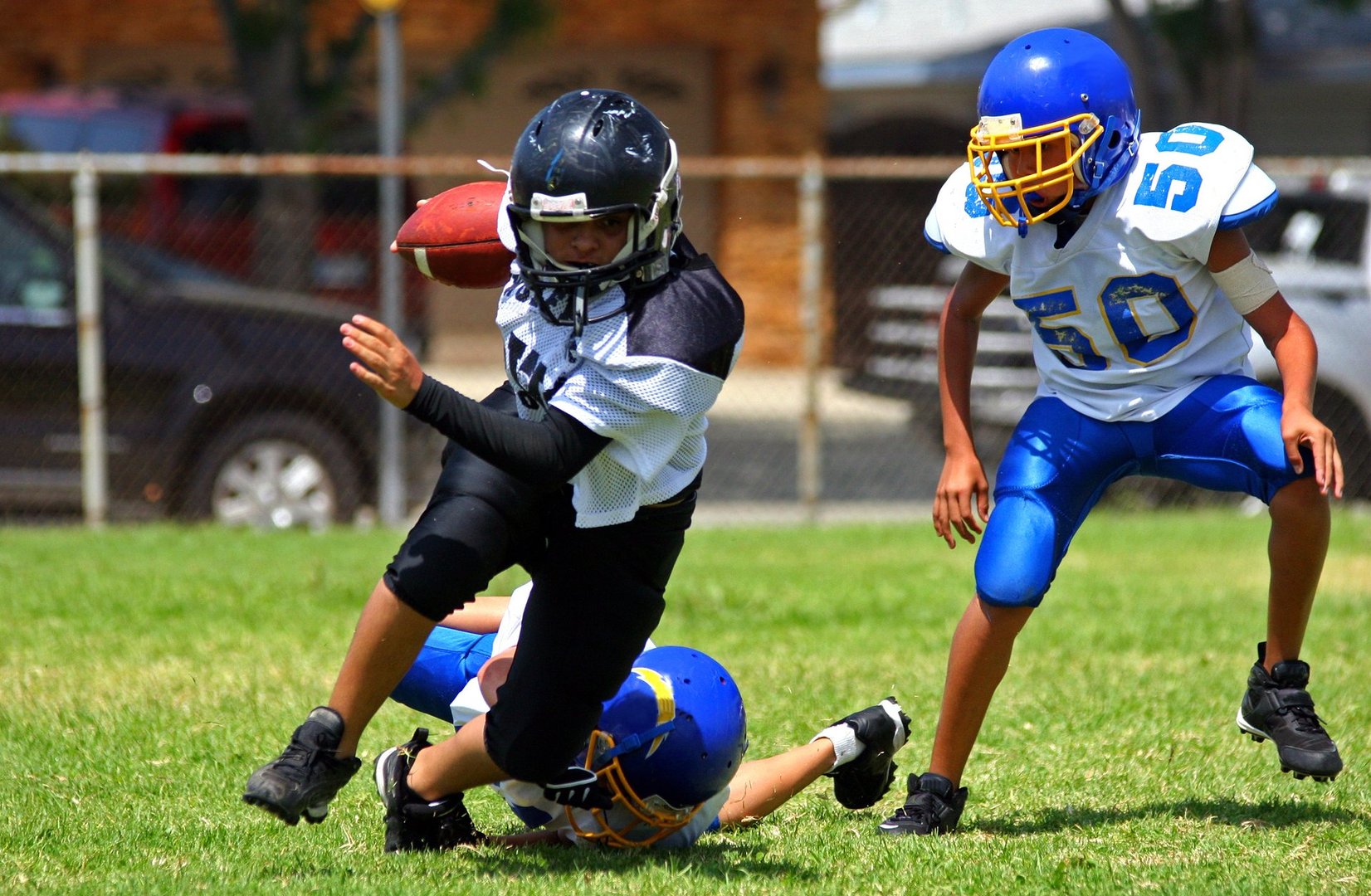 Young american football player running back breaking away from an attempted tackle. All logos and trademarks from uniforms, helmets and cleats have been removed in Photoshop