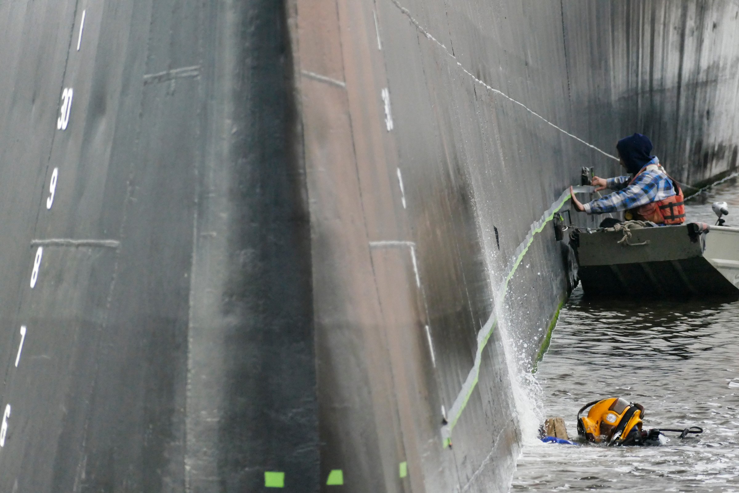 Diver working on hull of USS Battleship Wisconsin, museum ship underwater maintenance