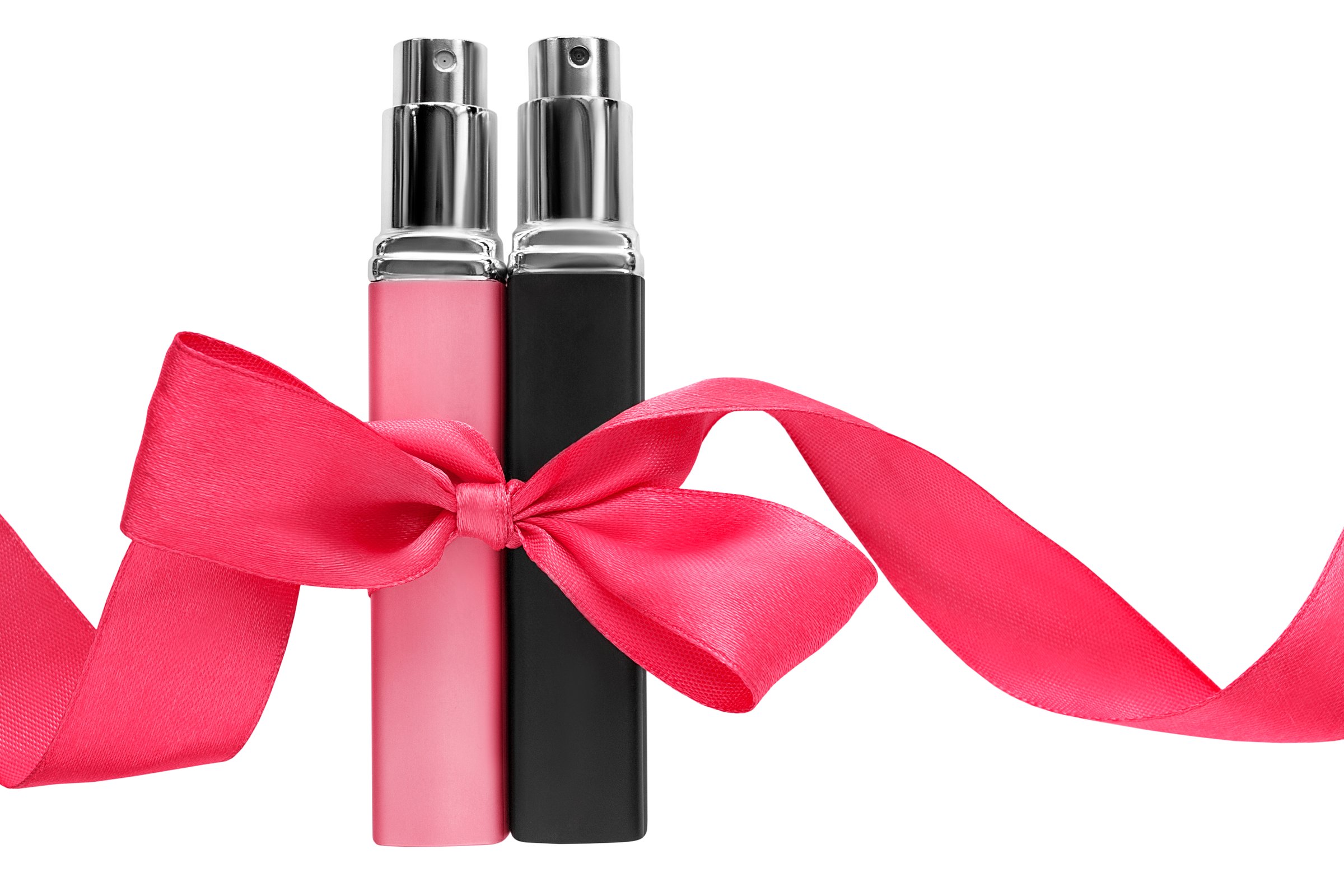 Black and pink perfume atomizers tied with pink ribbon bow isolated over white