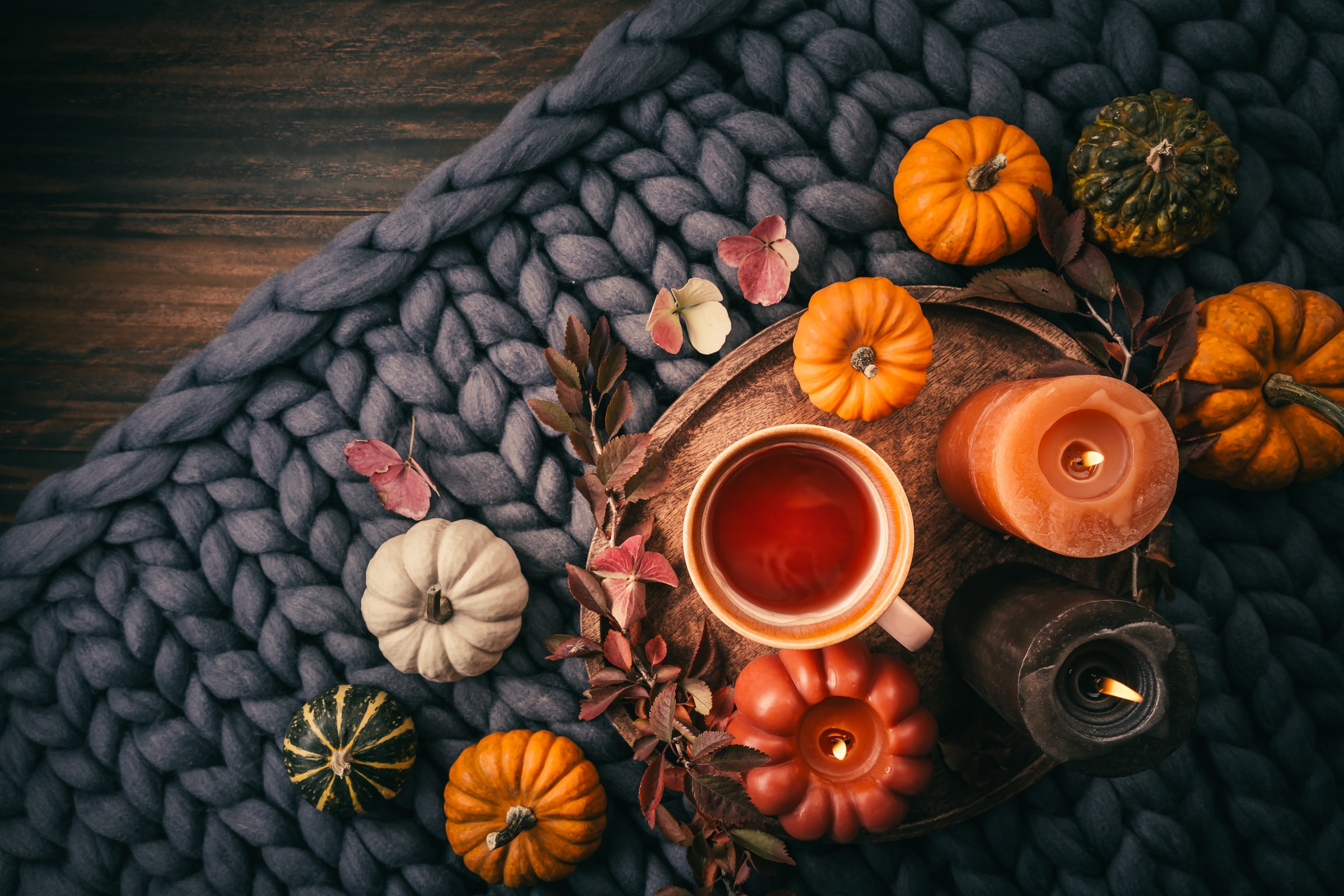 Cozy still life with fruit tea, pumpkins and candles for autumn days and Thanksgiving
