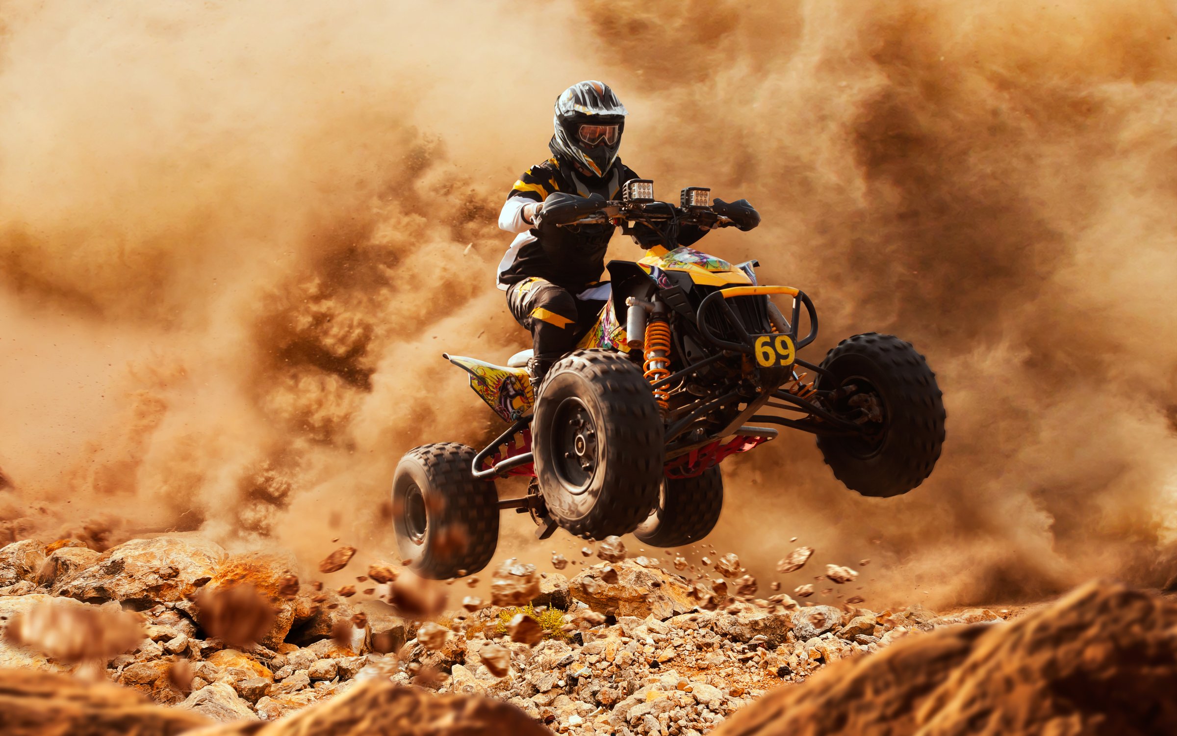 Quad bike in dust cloud, sand quarry on background. ATV Rider in the action.