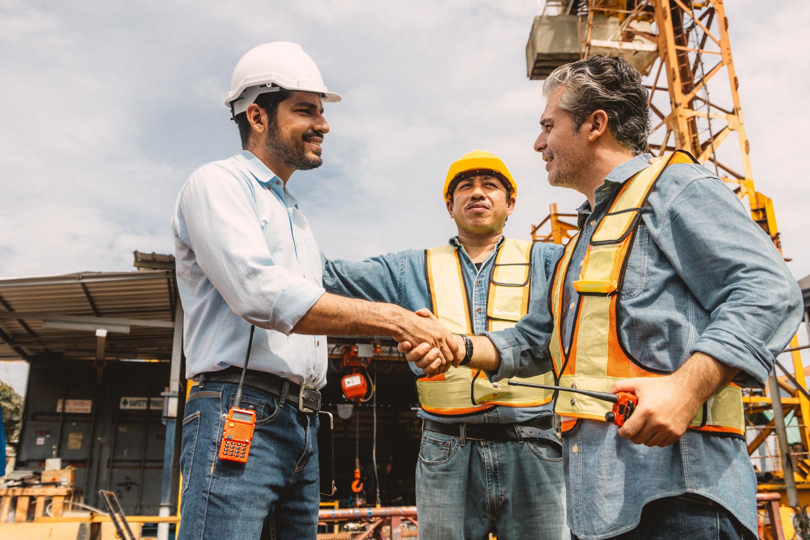 Workers team hand shaking deal at construction site