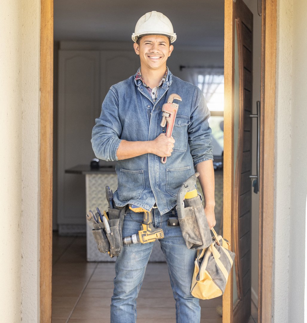 Handyman in portrait, maintenance job and tools with construction and home renovation, builder with smile. Professional contractor, DIY skills and manual work with wrench, male with helmet for safety