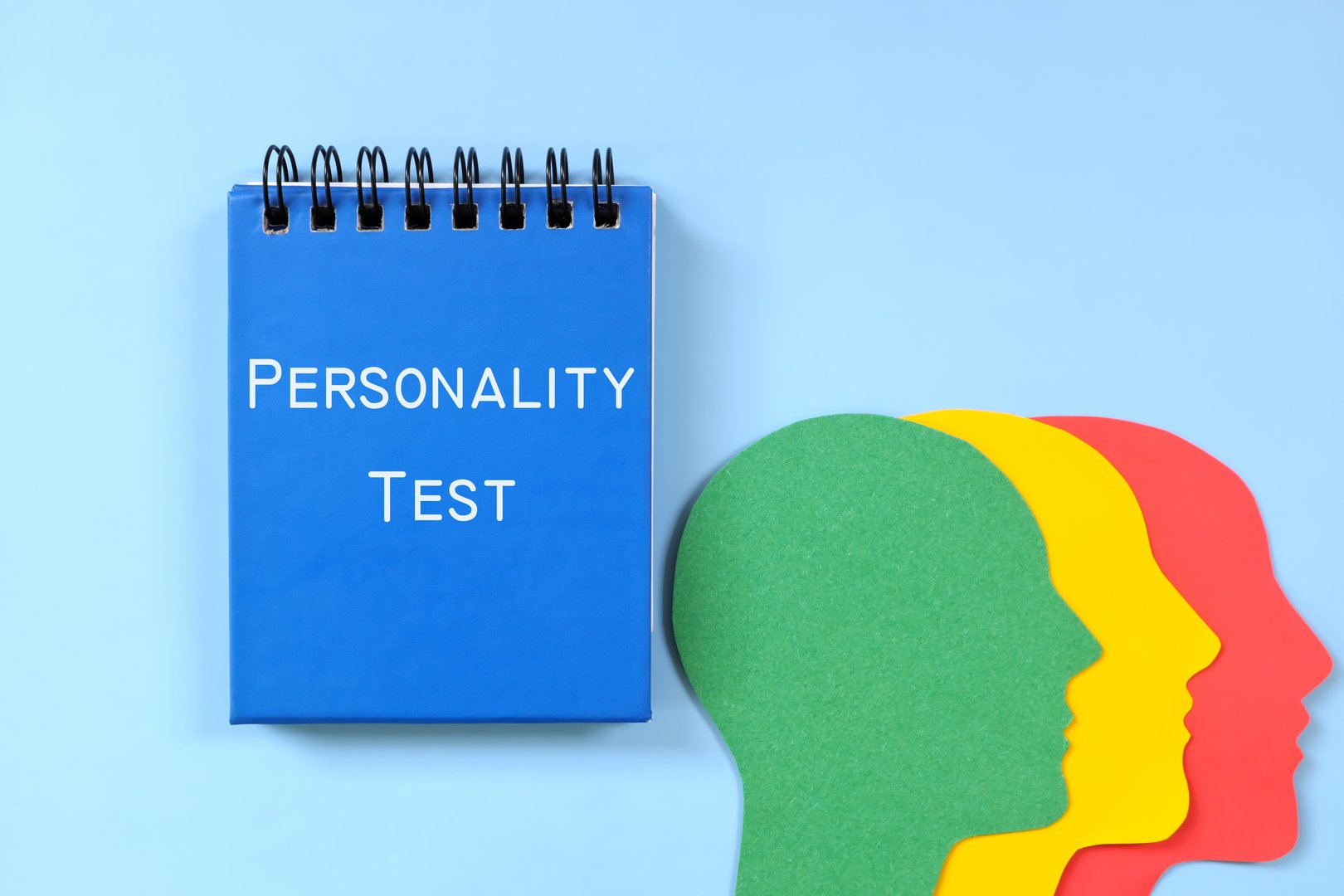 Personality test concept. Word written on blue notepad with human head profile silhouette.