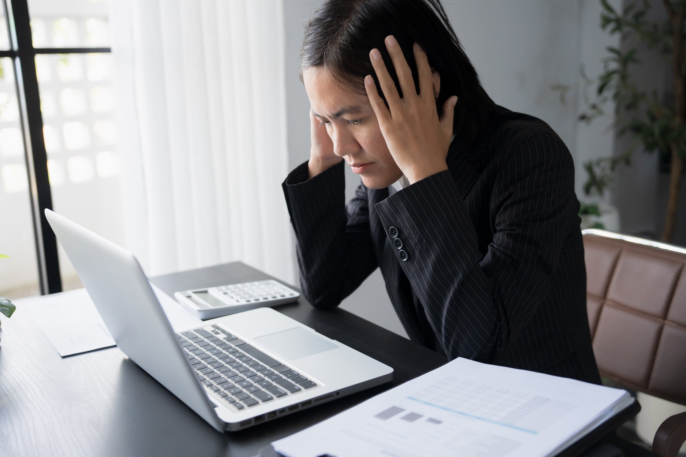 Burnout concept. Asian Business woman touching forehead having headache boring job and tired emotional pain and professional person depressed over risk