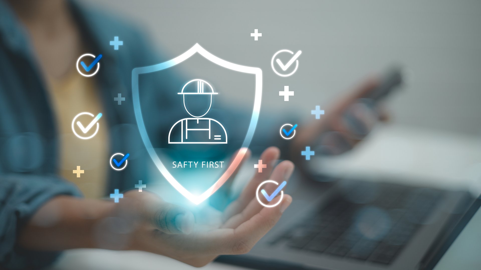 Business hand holding digital safety icon with worker helmet and checklists. Concept for workplace safety, health and safety, risk management, compliance, protection, digital monitoring.